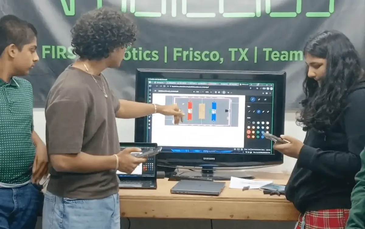 Students reviewing a design on screen in front of the Radicubs banner
